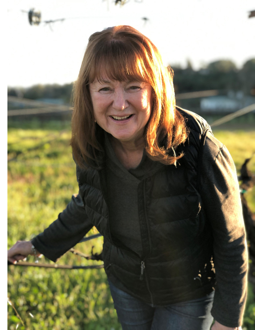 Linda Champagne standing in the vineyard