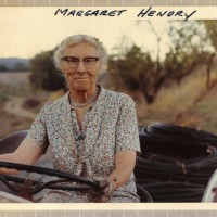 Vintage photo of Margaret Hendry on the tractor in front of the winery, 1973